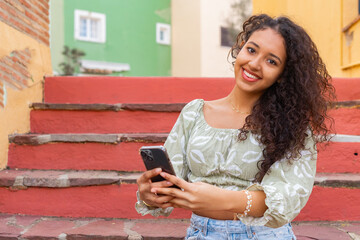 Young tourist using smartphone on colorful stairs in Mexico