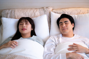 ベッドで眠る日本人男女