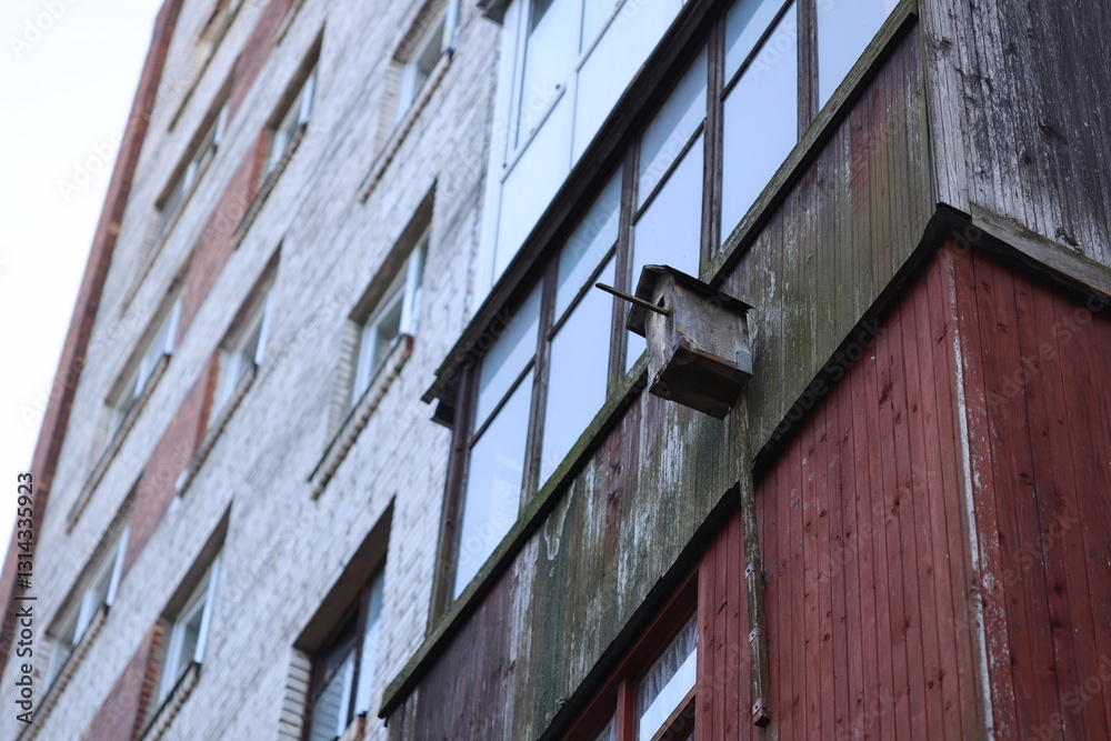 Poster a small birdhouse attached to the side of a building, ideal for using in illustrations or designs re