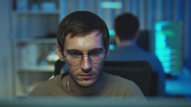Observe the concentrated gaze of a programmer as they navigate solutions in broadcast programming and coding languages.


