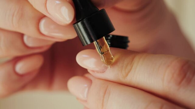 Woman applying nourishing moisturizing oil on cuticles after manicure. Concept of hand care and beauty. High quality 4k footage