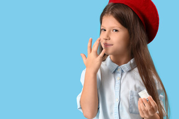 Fototapeta premium Skincare routine for children, young girl applying moisturizer to face