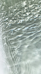 Pure water with reflections sunlight in slow motion. Water surface texture top view. Sun and shadows. Motion clean swimming pool ripples and wave.
