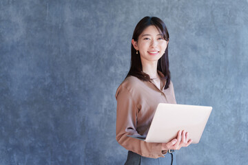 ノートパソコンを持つ女性ビジネスマン