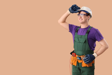 Male electrician on brown background