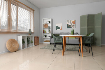 Stylish light living room with soft sofa, table and shelving unit