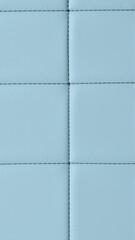 Fototapeta premium The surface texture of artificial leather is light gray, the surface is stitched in the form of diamonds, squares, rectangles. Eco-leather in a kilt. 