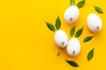 Easter eggs in shape of bunny with spring leaves and willow buds, top view
