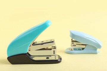 Blue staplers on yellow background