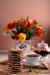 photo Enjoy a Serene Afternoon Tea with Crunchy Cookies, Aromatic Brew, and Vibrant Flowers Creating a Perfect Relaxing Ambiance for Unwinding and Pleasure