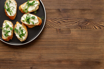 Toasts with with cream cheese and micro greens peas, healthy snack. Top view