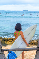 Obraz premium Surfer walking on the beach holding surfboard in siargao island, philippines