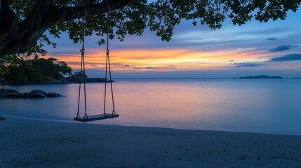 Empty swing on beach at sunset