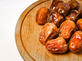 bowl of dates on a white background, isolated with a clipping path. Dried date fruits in a wooden...