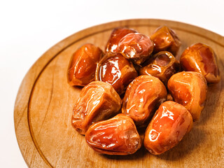 bowl of dates on a white background, isolated with a clipping path. Dried date fruits in a wooden...