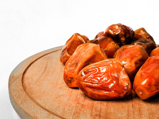 bowl of dates on a white background, isolated with a clipping path. Dried date fruits in a wooden plate.