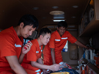 Portrait of an emergency care worker standing in front of an ambulance holding a walkie-talkie, waiting for a call and looking intently at helping an accident victim.