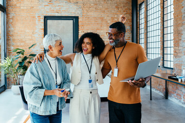 Smiling diverse colleagues enjoy a successful day in a bright workspace