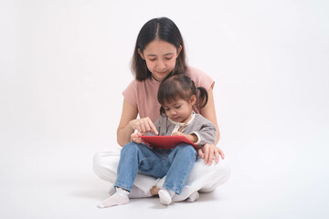 Mother and daughter sitting together with a tablet in a light setting, showcasing modern family bonding through technology and shared learning.