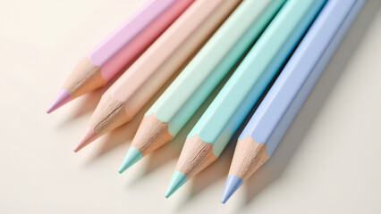 Fototapeta premium A close-up of pastel-colored pencils arranged neatly, showcasing their pointed tips against a soft, light background.