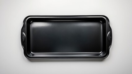 Nonstick baking sheet displayed on a white background. Unfilled rectangular oven tray suitable for baking and roasting. Black baking pan for culinary and food design. Kitchen utensils. Aerial view.