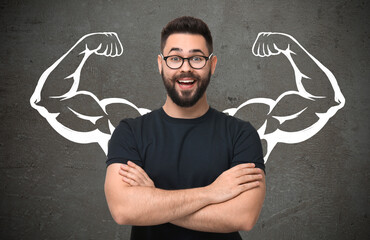Happy man with drawing of strong arms behind him on grey background