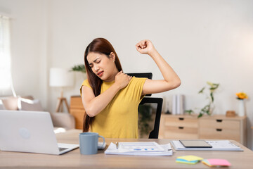 Young business women is relaxing and stretching while working on laptop in office space.