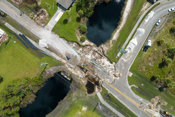 Destroyed bridge after hurricane flooding in Florida. Construction equipment at roadwork site....