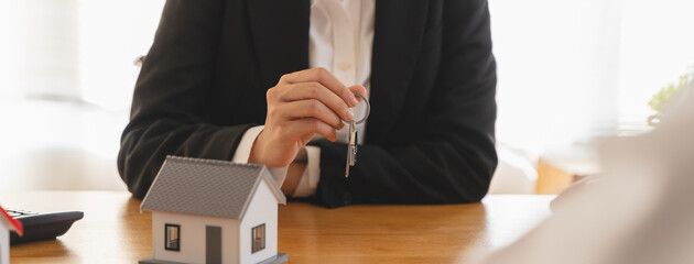 Realtor agent giving a key of apartment to new owner after signed lease agreement.