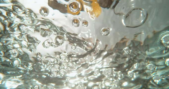Ultra slow-motion shot of pouring macaroni pasta into pot with boiling water. 4k close-up view