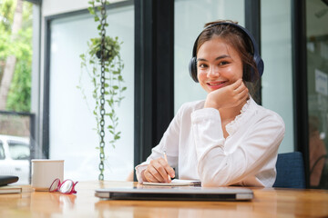 Smiling young woman enjoying remote work in a cozy workspace