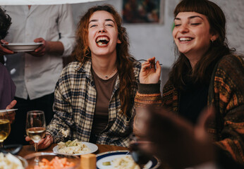 Two friends share laughter and joy while dining together, creating a warm and sociable atmosphere.