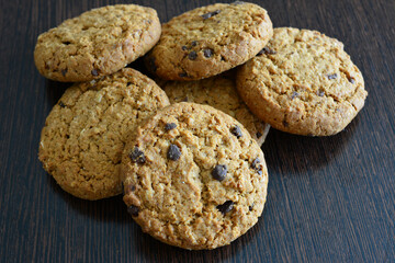 Delicious Oatmeal Chocolate Chip Cookies on dark wooden background