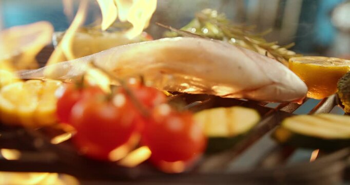 Sizzling sea bream falling on the fire in slow-motion, grilling on barbecue