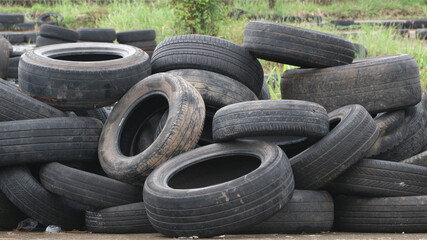 Landfill with old tires and tyres for recycling. Reuse of the waste rubber tyres. Disposal of waste tires. Worn out wheels for recycling. Tyre dump burning plant.
