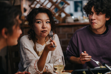 A group of friends share a warm dinner gathering, enjoying food and friendly conversations in a cozy and relaxed home environment.