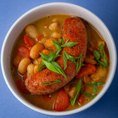 Beans cooked in cocnut milk with carrots chives and pork sausage.