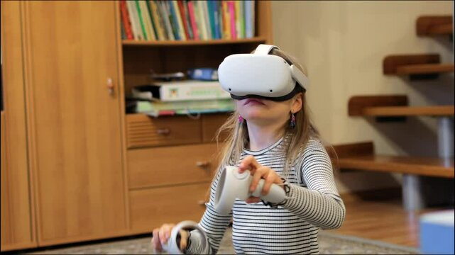 A young girl with long blonde hair wears a virtual reality headset, and holds motion controllers while engaging with an immersive digital experience in a home setting