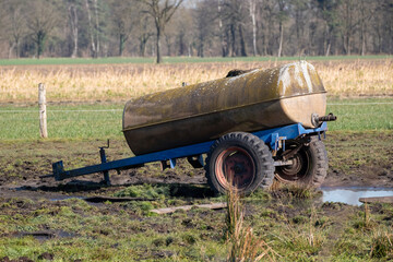 Mossy tank trailer fertilizing a field with liquid manure