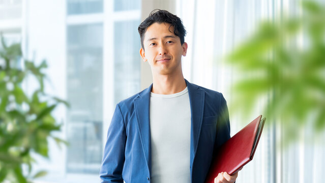 バインダーを持って微笑む男性ビジネスマン