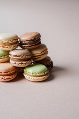 Multicolored macarons desserts with minimalistic beige background and copy space