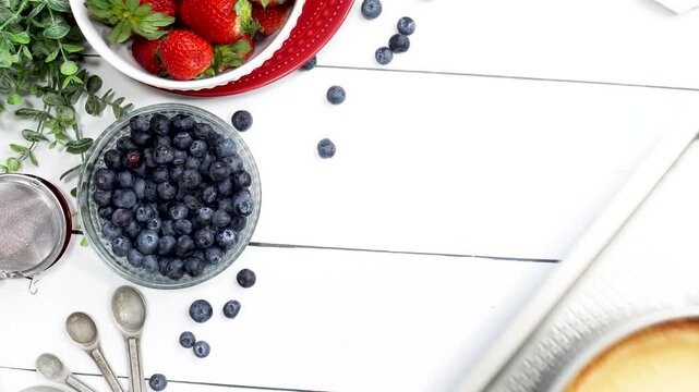 Baking a New York style cheesecake with strawberries, blueberries and a light lemon taste.   Baking a cheesecake in the kitchen with fresh berries.  Easy recipe for a classic cheesecake
