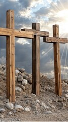Naklejka premium Wooden crosses stand prominently against a dramatic sky at sunset, symbolizing reflection and hope in a serene landscape