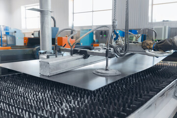 Male worker use Vacuum transporter operating industrial machinery to cnc laser