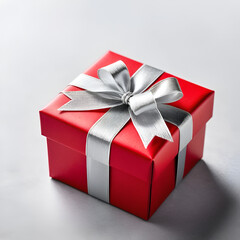 Obraz premium A beautifully wrapped red gift box with silver ribbon ready to be presented for a special occasion or celebration