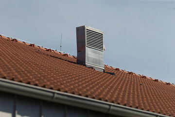 A house featuring a distinctively designed roof complete with a chimney that is elegantly positioned on top of it for aesthetic appeal and functionality