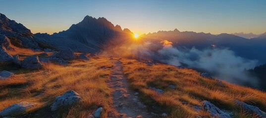 Golden hour light illuminating hiking path and panoramic view of tatra mountains with clouds at sunrise in poland © oksa_studio