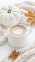 Warm beverage filling white ceramic mug coffee resting on soft beige knit sweater, nearby white pumpkin and scattered autumn leaves depicting seasonal comfort aesthetic background