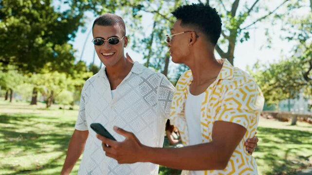 Phone, nature and friends in conversation laughing for celebrity gossip with online blog. Happy, social networking and men with cellphone browsing media with reaction for funny post outdoor in park.
