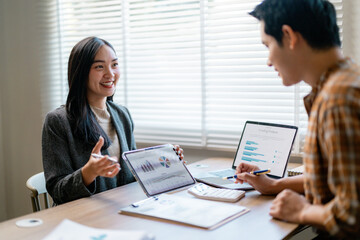 Business partners discussing marketing strategy using digital devices and analyzing financial statistics, charts and graphs